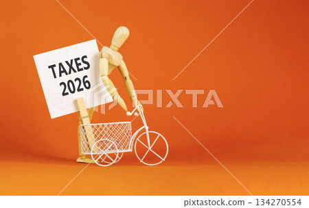 Taxes 2026 new year symbol. Concept words Taxes 2026 on beautiful white card. Beautiful orange paper background. Businessman's model. Business and taxes 2026 new year concept. Copy space. 134270554