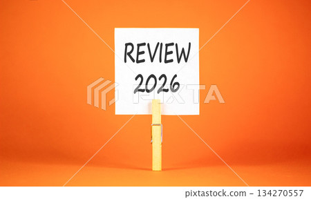 Review 2026 symbol. Concept words Review 2026 on beautiful white paper on wooden clothespin. Beautiful orange background. Business and review 2026 concept. Copy space. Review 2026 symbol. Concept words Review 2026 on beautiful white paper on wooden clothespin. Beautiful orange background. Business and review 2026 concept. Copy space. 134270557