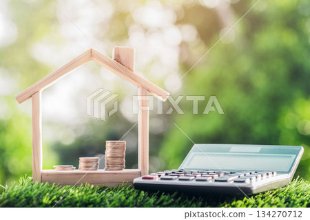Coins is placed in a model house and a calculator on the grass. planning savings money of coins to buy a home Coins is placed in a model house and a calculator on the grass. planning savings money of coins to buy a home 134270712