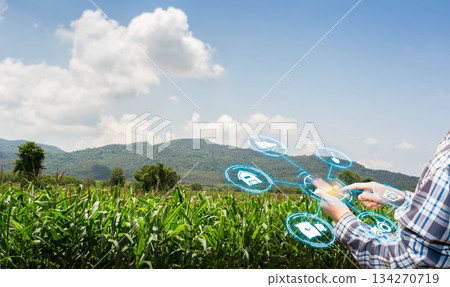 asian male farmer working in corn farm To collect data to study. Innovation technology for Develop farms to improve production efficiency. 134270719