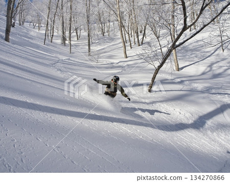Snowboarders skiing down the frost-covered River Line and Tree Run courses at Madarao Kogen Ski Resort in winter Snowboarders skiing down the frost-covered River Line and Tree Run courses at Madarao Kogen Ski Resort in winter 134270866