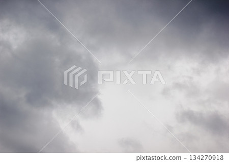 A dramatic and moody sky filled with thick, dark grey storm clouds creating a textured background 134270918