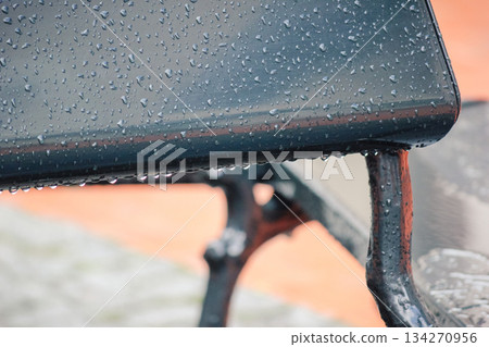 Close up of a dark, wet table surface covered in water puddles and rain with abstract patterns Close up of a dark, wet table surface covered in water puddles and rain with abstract patterns 134270956