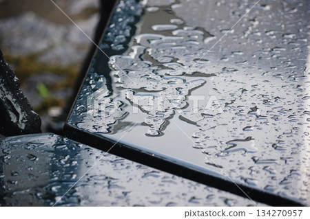 Close up of a dark, wet table surface covered in water puddles and rain with abstract patterns Close up of a dark, wet table surface covered in water puddles and rain with abstract patterns 134270957