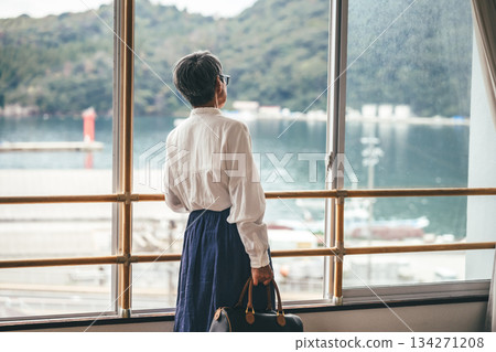 Woman looking out the window at the harbor 134271208