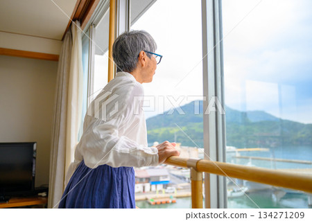 Elderly woman looking out the window 134271209