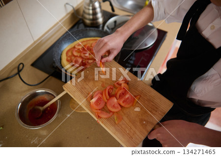 Fresh Tomato Pizza Prep: Chopped Tomatoes On Cutting Board While Cooking In Kitchen Fresh Tomato Pizza Prep: Chopped Tomatoes On Cutting Board While Cooking In Kitchen 134271465