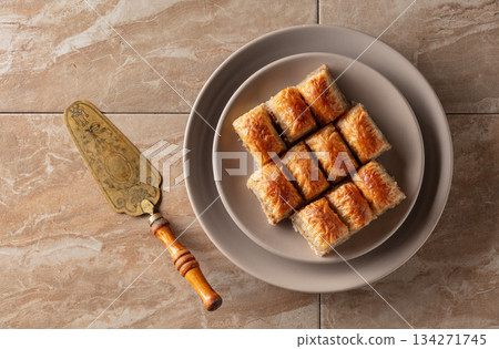 Baklava with walnuts on a beige plate. Baklava with walnuts on a beige plate. 134271745