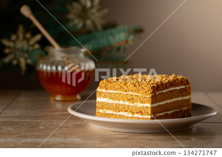 Layered honey cake on a background of Christmas tree. 134271747