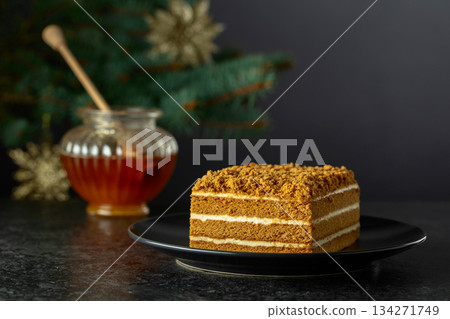Layered honey cake on a background of Christmas tree. Layered honey cake on a background of Christmas tree. 134271749