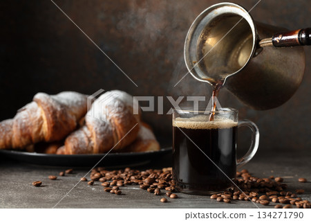Croissants and black coffee on a kitchen table. Croissants and black coffee on a kitchen table. 134271790