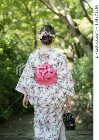夏季和服時尚。特寫鏡頭展現了綠色庭院中和服的髮型和腰帶。日本京都府京都市。 134271869