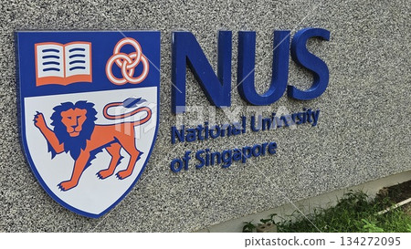The NUS emblem with lion, rings, and book stands proudly on a stone wall, symbolizing strength, unity The NUS emblem with lion, rings, and book stands proudly on a stone wall, symbolizing strength, unity 134272095