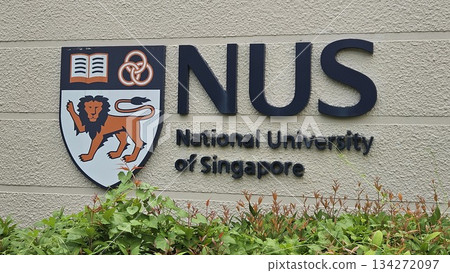 The NUS emblem with lion, rings, and book stands proudly on a stone wall, symbolizing strength, unity The NUS emblem with lion, rings, and book stands proudly on a stone wall, symbolizing strength, unity 134272097