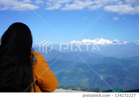 Young woman looking at snowcapped Himalayan mountain peaks from a scenic viewpoint at Darjeeling 134272227