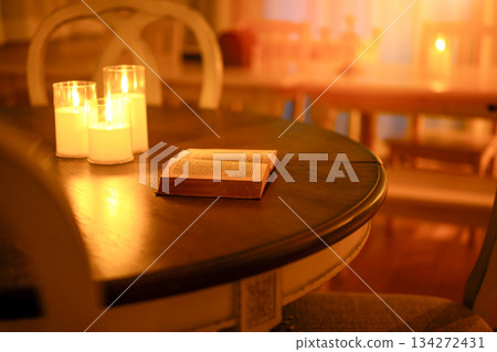 Candlelit table and open book 134272431