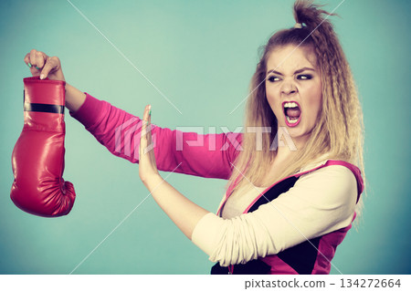 Disgusted woman holding boxing glove Disgusted woman holding boxing glove 134272664
