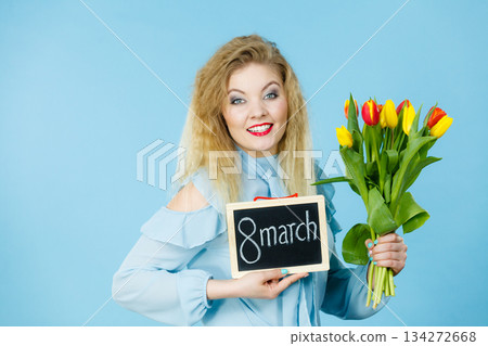 Woman holds tulips, board with text 8 march Woman holds tulips, board with text 8 march 134272668