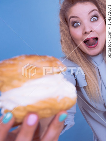 Funny woman holds cream puff cake 134272671