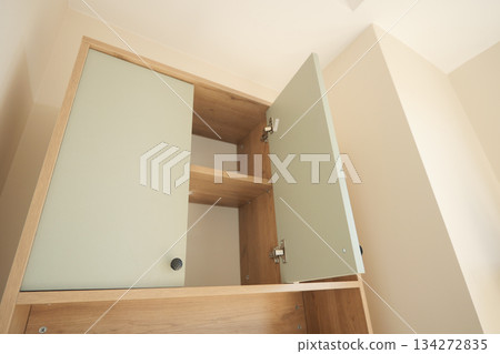 Cabinet with open doors showing empty shelves inside Cabinet with open doors showing empty shelves inside 134272835
