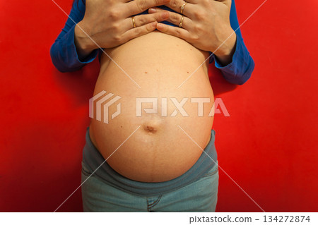 Adult woman showing her pregnant belly Adult woman showing her pregnant belly 134272874
