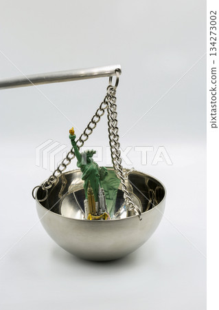Statue of Liberty figurine on metal balance scale closeup. 134273002