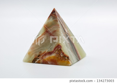 Polished stone pyramid abstract pattern closeup on white. 134273003
