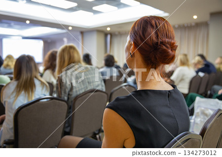 Business seminar attendee listening to presentation Business seminar attendee listening to presentation 134273012