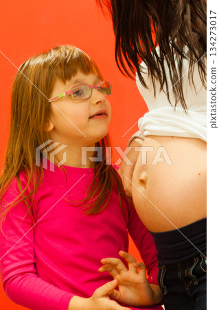 Daughter looking pregnant mother big belly 134273017