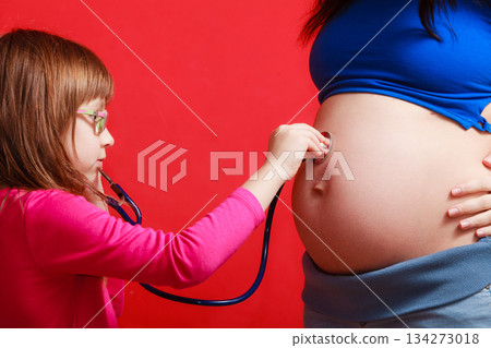 Daughter using stethoscope on pregnant mother Daughter using stethoscope on pregnant mother 134273018