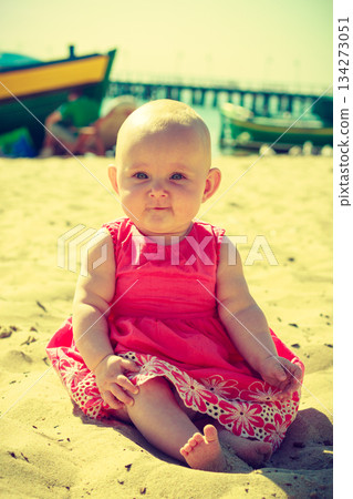 Little baby sitting and playing on beach Little baby sitting and playing on beach 134273051