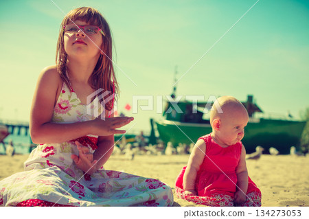 Toddler girl having fun with child on beach. Toddler girl having fun with child on beach. 134273053