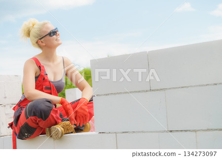 Woman taking break on construction site Woman taking break on construction site 134273097