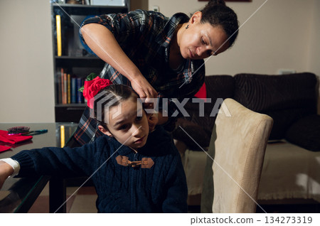Mother Styles Daughter's Hair At Home, Flower Accessory In Hair, Cozy Family Moment Mother Styles Daughter's Hair At Home, Flower Accessory In Hair, Cozy Family Moment 134273319