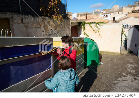 Children Explore Recycling Bins In Sunny Urban Alley With Colorful Containers Children Explore Recycling Bins In Sunny Urban Alley With Colorful Containers 134273404