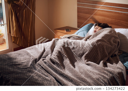 Cozy Morning Sleep: Person Resting in Bed Under Thick Gray Blanket in Bedroom Cozy Morning Sleep: Person Resting in Bed Under Thick Gray Blanket in Bedroom 134273422