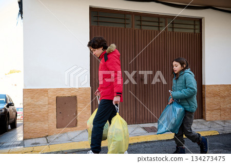 Two Children Walking Home With Shopping Bags On a Busy Winter City Street Two Children Walking Home With Shopping Bags On a Busy Winter City Street 134273475