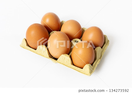 Six organic brown eggs in a carton isolated on white background 134273592