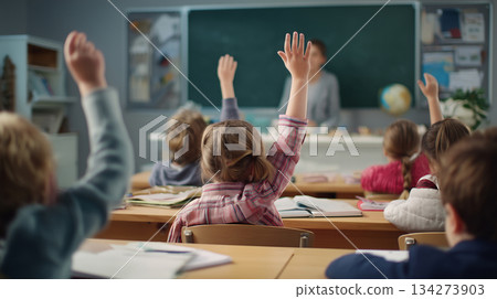 Children Raising Hands in Classroom Facing Chalkboard Children Raising Hands in Classroom Facing Chalkboard 134273903