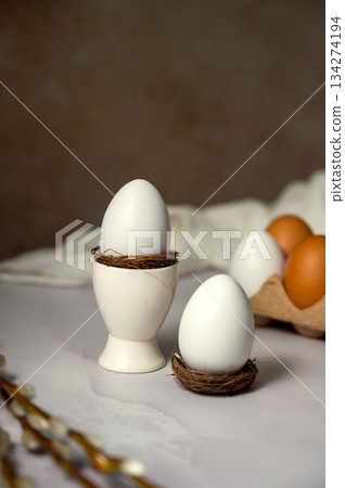 Easter spring background. Egg in ceramic egg holder, with willow pussy branch. Minimalistic Easter spring background. Egg in ceramic egg holder, with willow pussy branch. Minimalistic 134274194