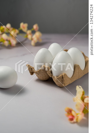 Easter spring background. Eggs in egg box with flowers. Minimalistic 134274224