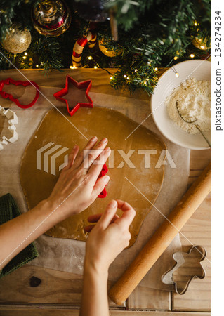 Holiday background. Woman cooking Christmas gingerbread cookies. Top view Holiday background. Woman cooking Christmas gingerbread cookies. Top view 134274234