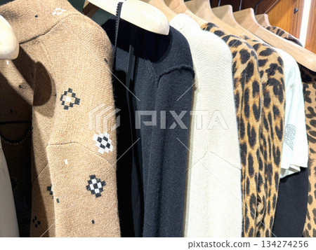 Warm winter sweaters hanging on rack in clothing store 134274256