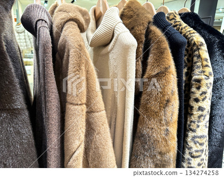 Eco friendly faux fur coats hanging on rack in store. Eco friendly faux fur coats hanging on rack in store. 134274258