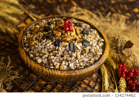 Kutya began the celebration of Christmas in Ukraine. Kutia with poppy seeds and honey. Christmas porridge kutya over wooden background. 134274462