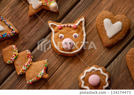 Celebration and cooking concept with christmas decoration and gingerbread cookies on wooden background. Flat lay, top view gingerbread cookies Celebration and cooking concept with christmas decoration and gingerbread cookies on wooden background. Flat lay, top view gingerbread cookies 134274473