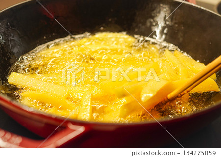 frying french fries in hot oil 134275059