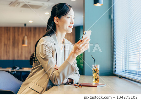 在一家咖啡館經營智能手機的女商人 134275102