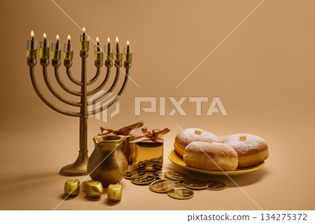 Hanukkah Celebration Setup. A menorah with lit candles, donuts, gelt, and gifts Hanukkah Celebration Setup. A menorah with lit candles, donuts, gelt, and gifts 134275372