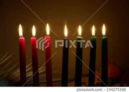 Candle Arrangement. Seven colorful candles lit in a dark, warm atmosphere. 134275386